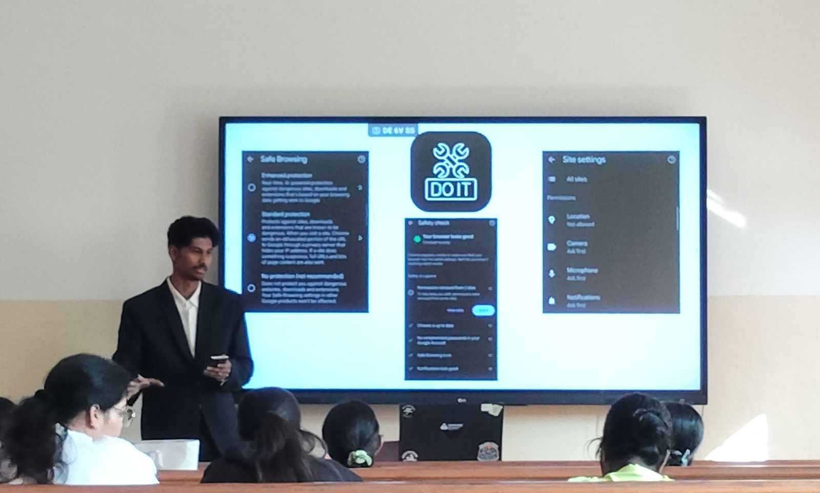 Kartik Bhattacharya delivering a browser security awareness talk with Chrome Safe Browsing and Site Settings displayed on a large screen