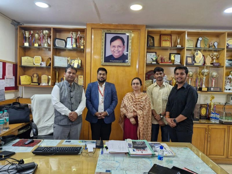 Kartik Bhattacharya and EthicBizz team meeting with educators and officials in a school principal's office with trophies and awards